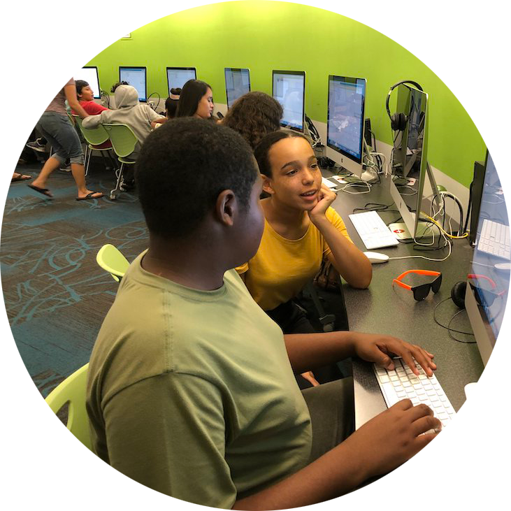 Young women showing older boy how to code